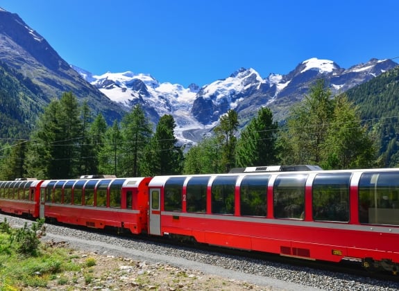 The Bernina Express A train travels through Alpine scenery with bright blue sky