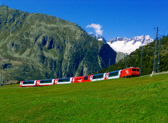 A train travels through lush swiss countryside