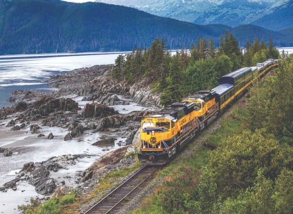 alaska railroad train next to a lake