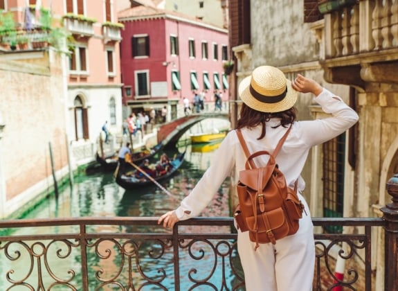 woman in venice with backpack and hat