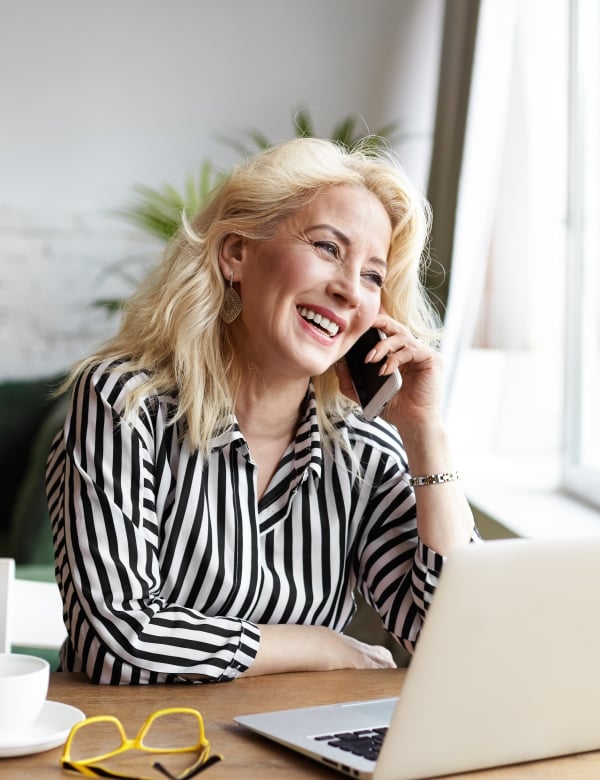 woman sitting at desk in front of open laptop