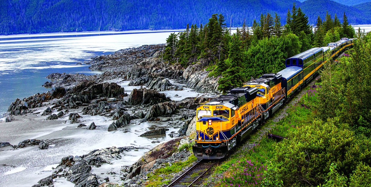 alaska railroad train next to a lake