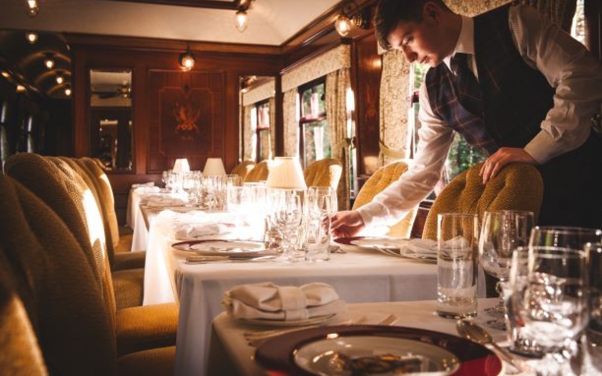 Dining onboard The Royal Scotsman A waiter lays the table ready for dinner onboard the train