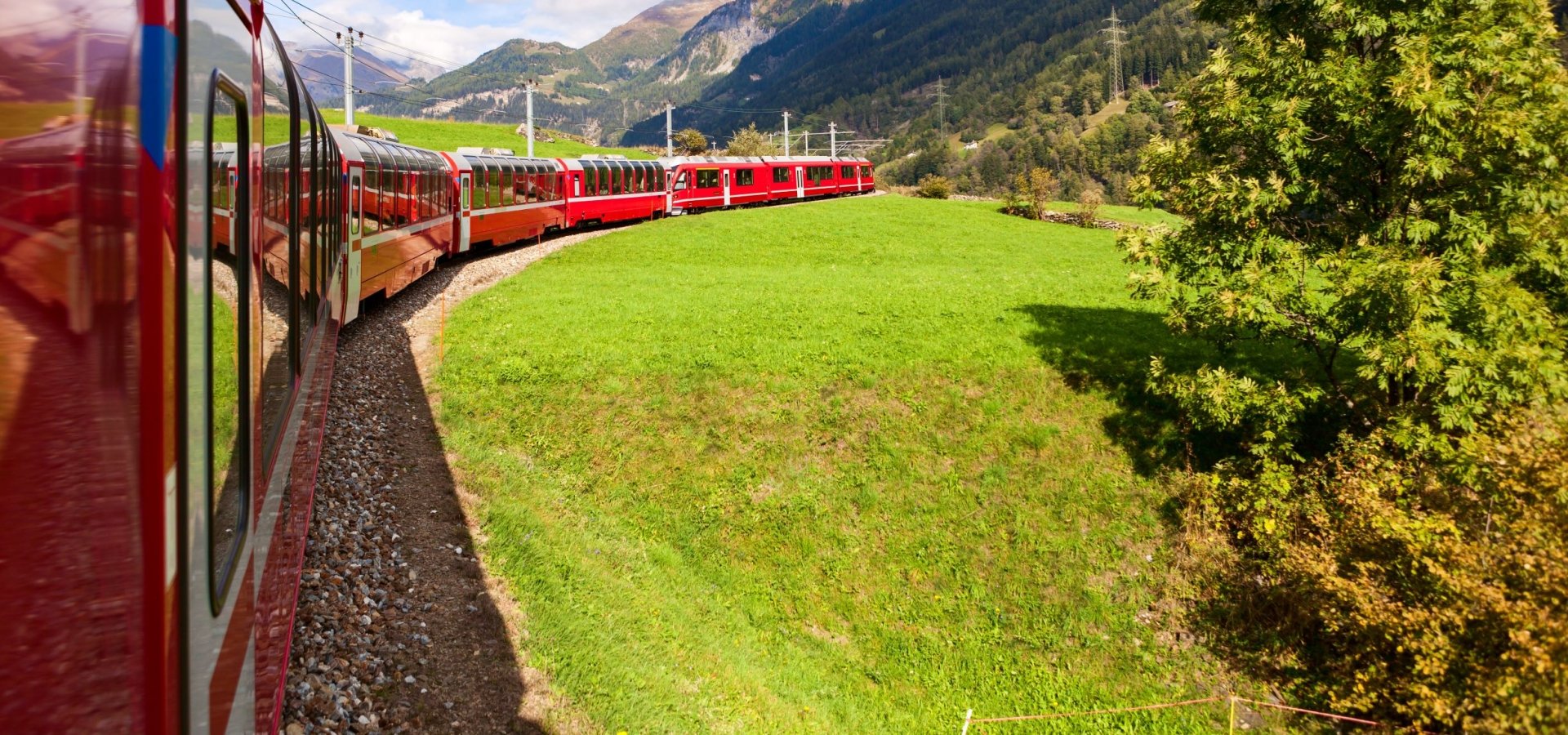 A train travels round a curved track in summer