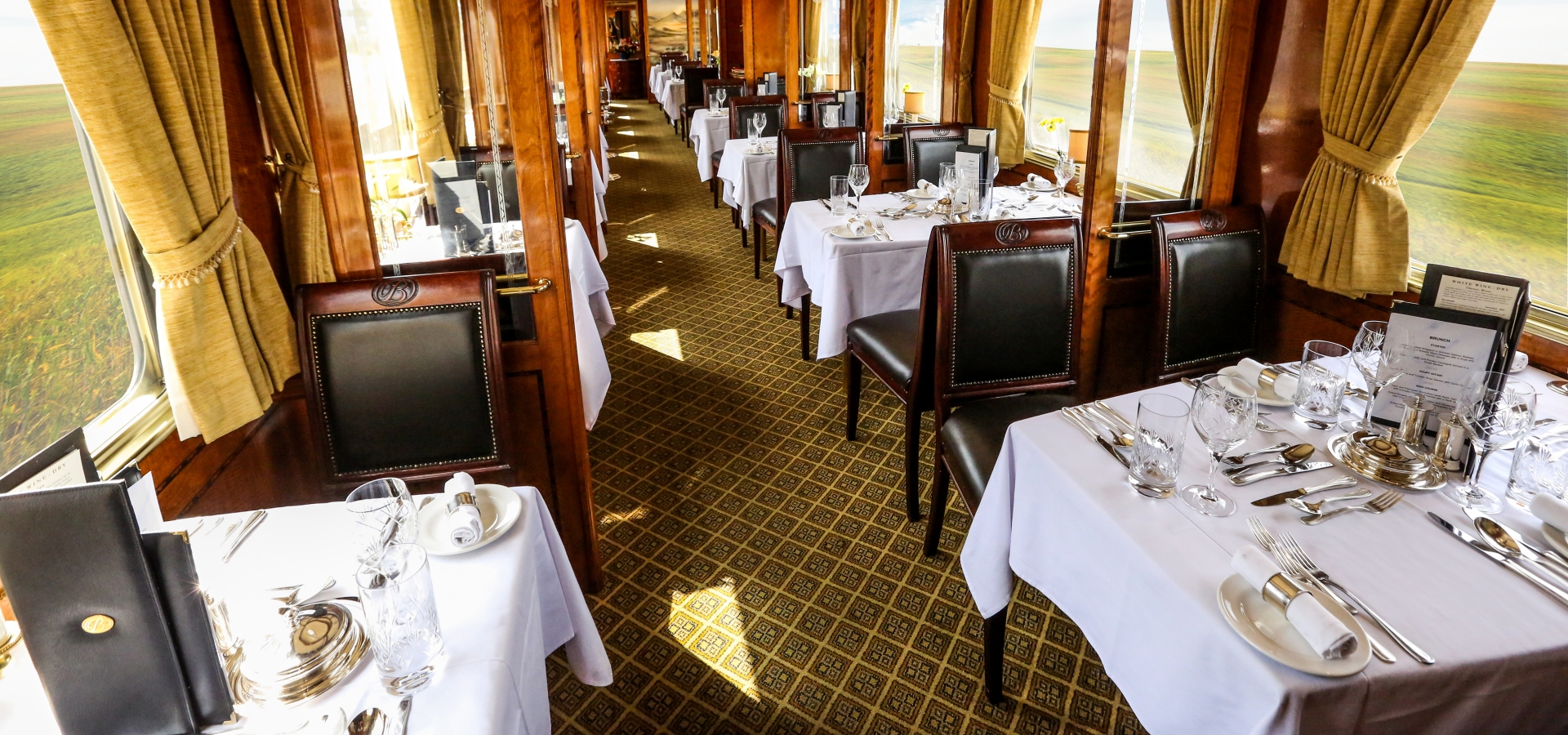 A train carriage laid out with dining tables and chairs