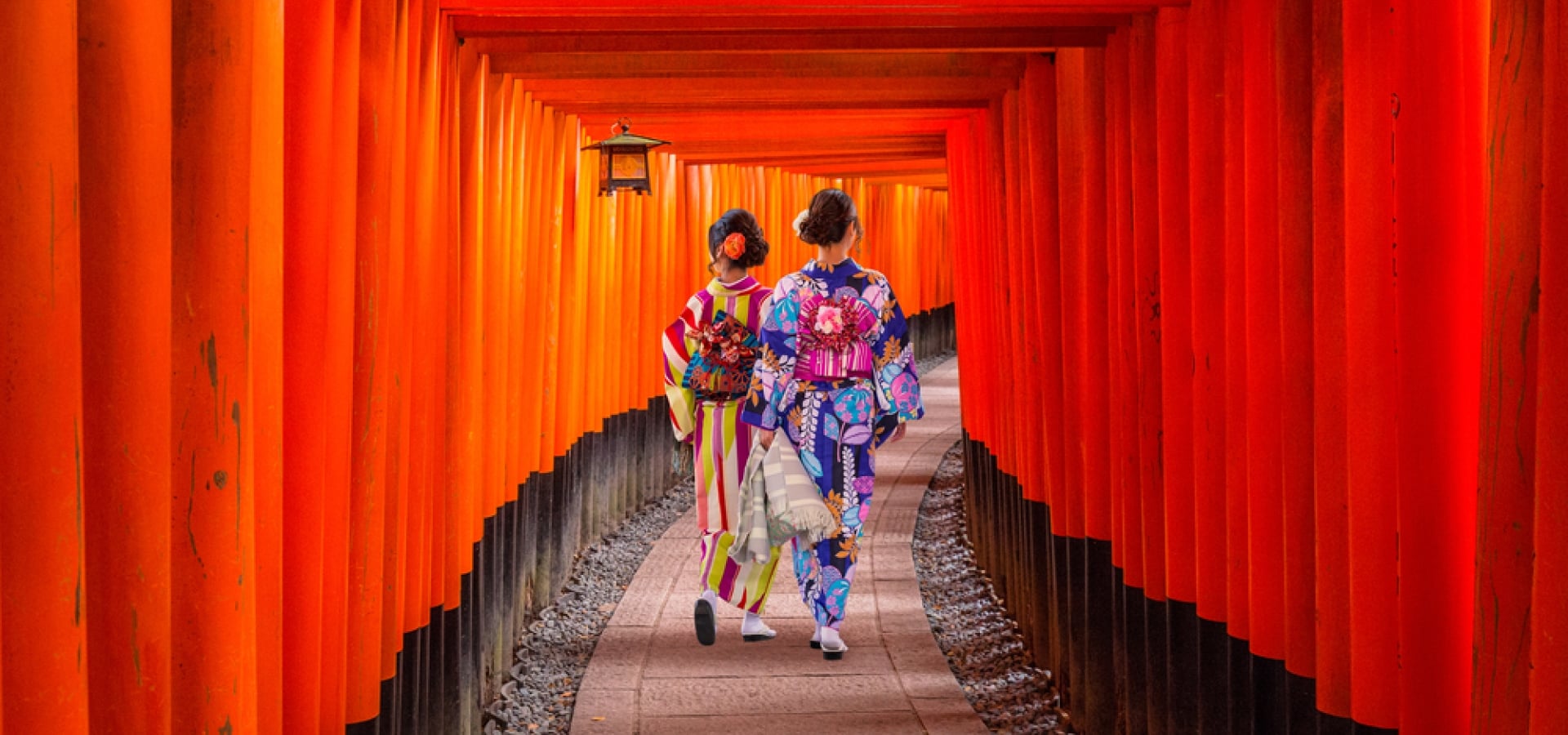 Women in traditional japanese kimonos walking at Fushimi Inari Shrine in Kyoto, Japan