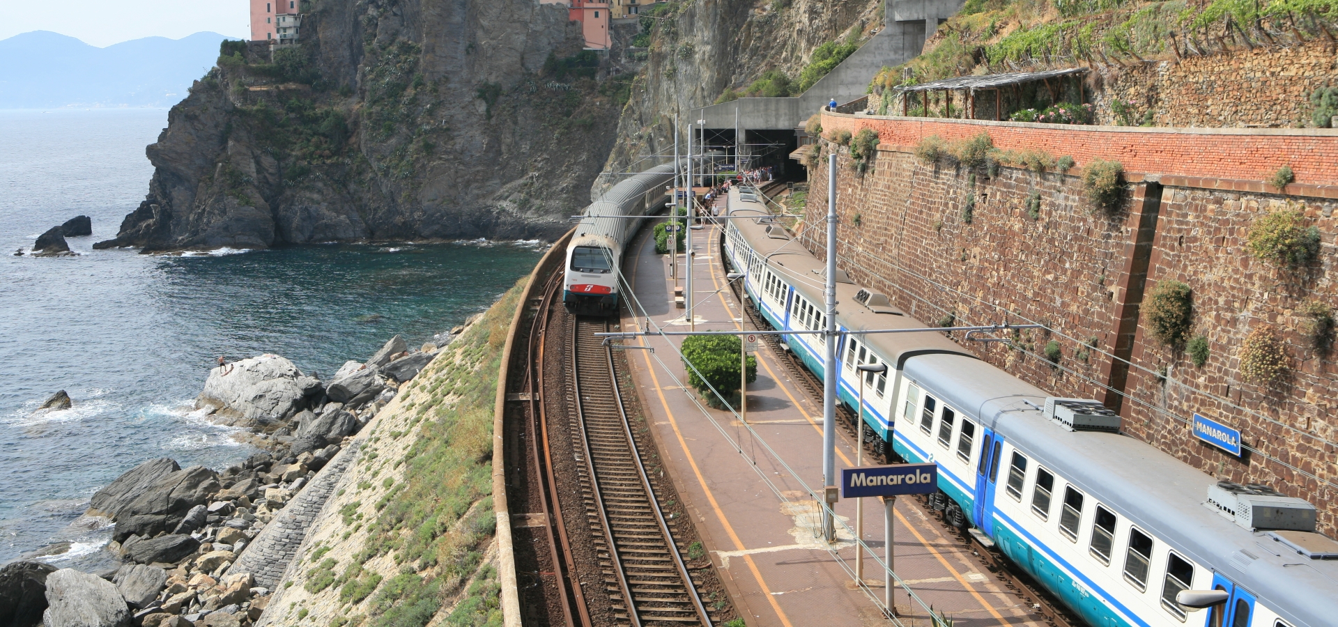 A train travels on a track alongside the coast