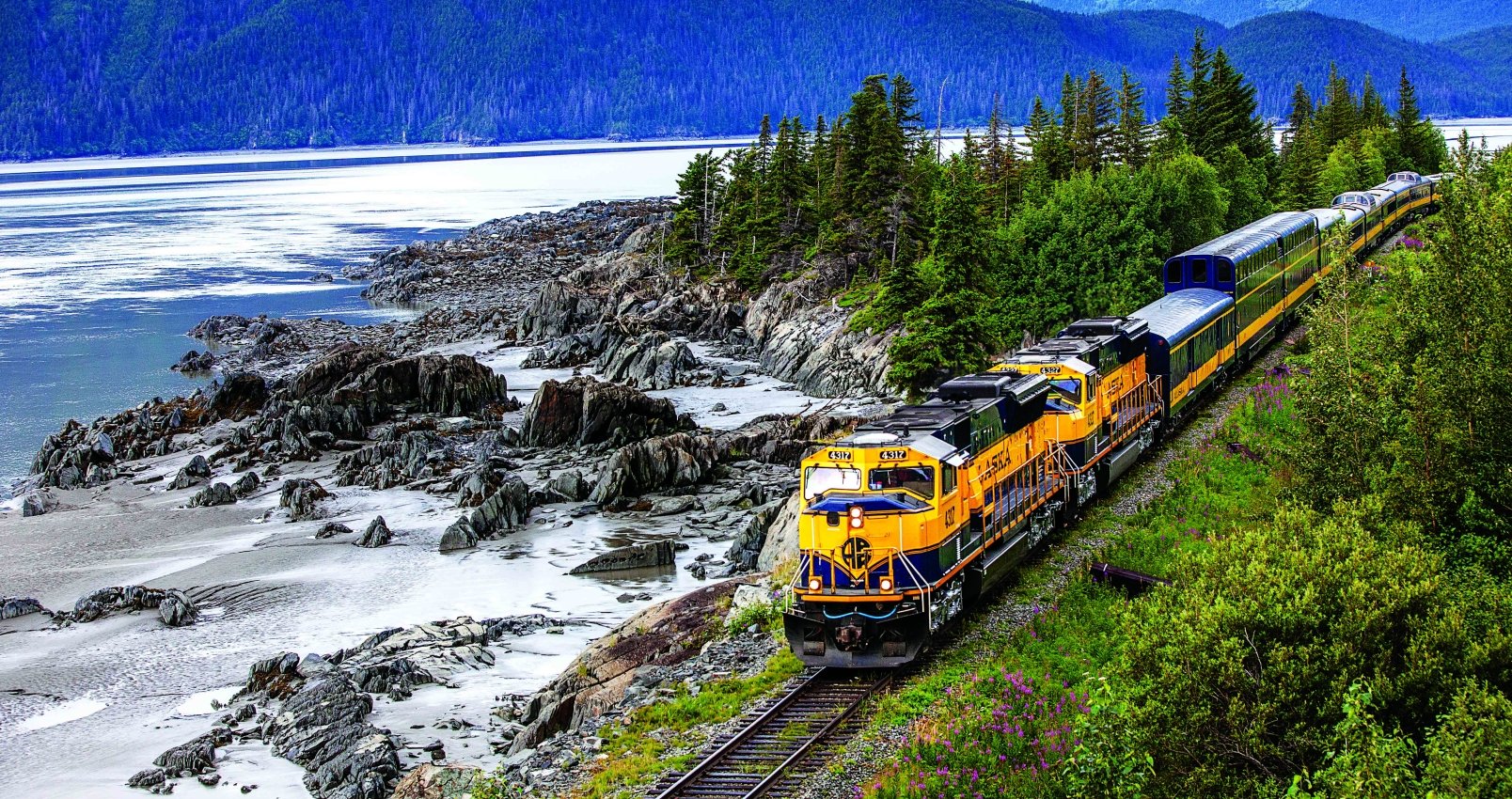 alaska railroad train next to a lake