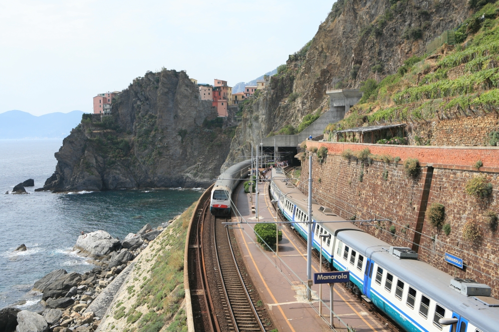 A train travels on a track alongside the coast