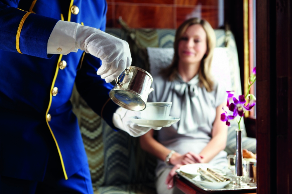Onboard the train, a steward serves customer afternoon tea