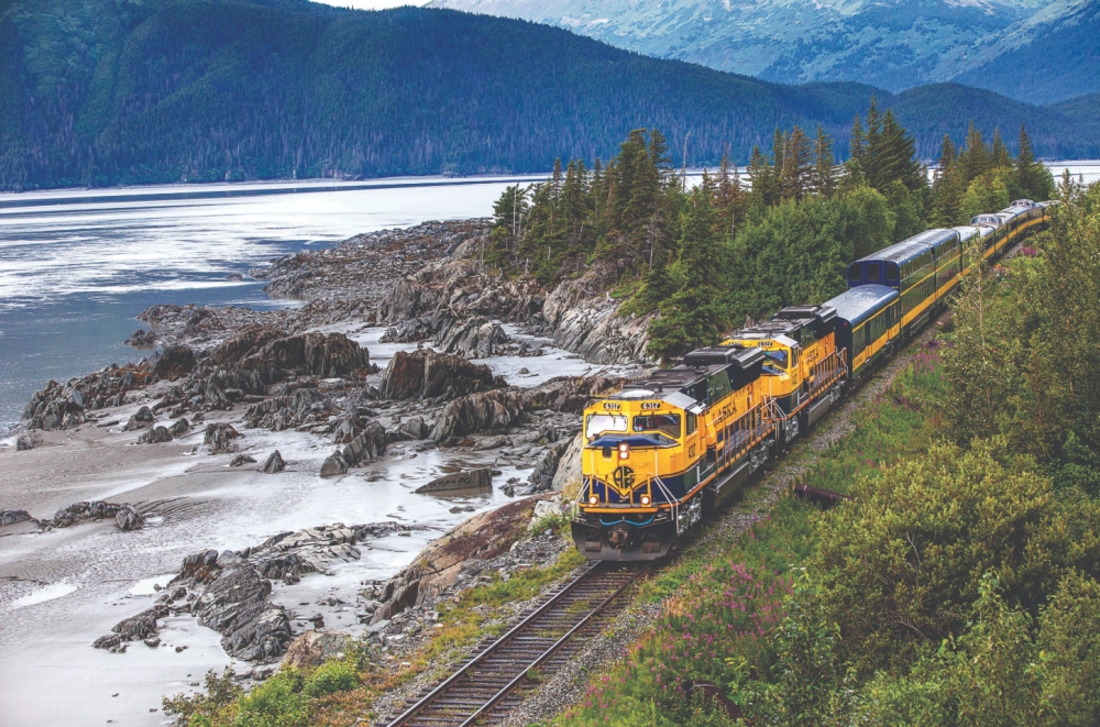 alaska railroad train next to a lake