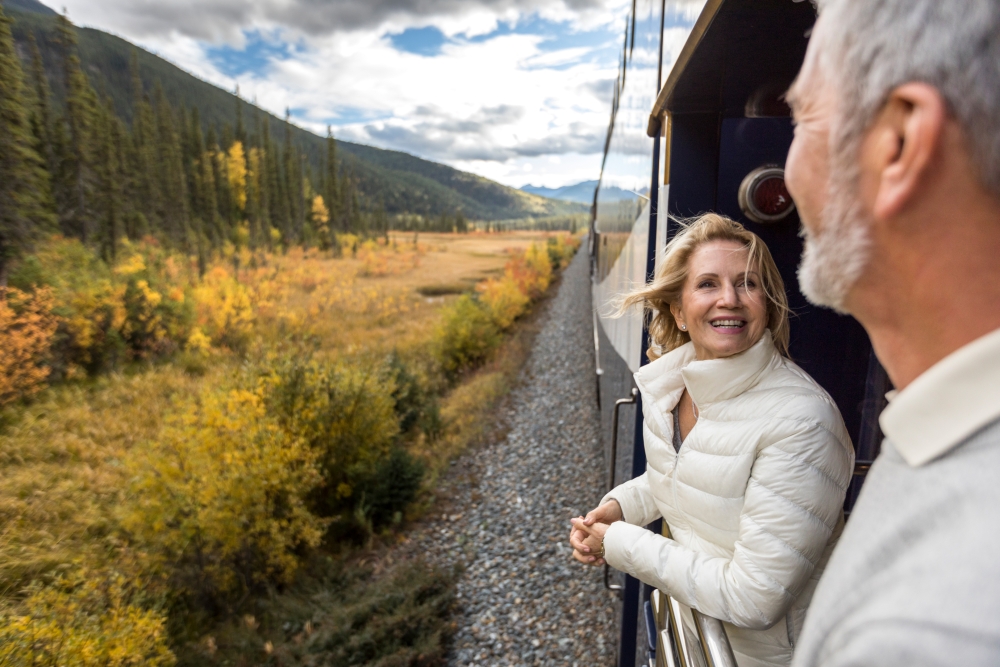 happy couple on platform of Rocky Mountaineer during train holiday